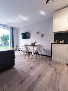 een keuken en eetkamer met een tafel en stoelen bij River House - Apartament z ogródkiem in Szczecin