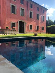 un edificio con una piscina d'acqua di fronte a un edificio di Hotel Villa Montanarini a Villarotta