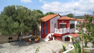 Casa pequeña de color rojo y blanco con patio en Vanna's Holiday House, en Ierissos
