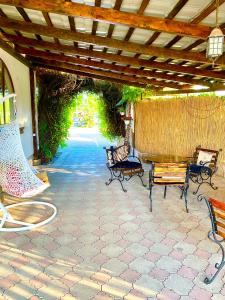 a patio with benches and a wooden pergola at Han in Selʼtso