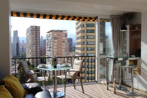 een balkon met een tafel en stoelen en uitzicht op de stad bij Lantana Suite-Turis Benidorm in Benidorm