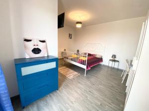 a bedroom with a blue dresser and a crib at 35 Passi dal mare B&B in Cirò Marina