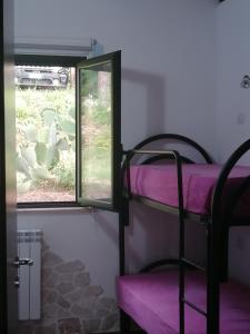 Zimmer mit 2 Etagenbetten und einem Fenster in der Unterkunft dastemi in Parghelia
