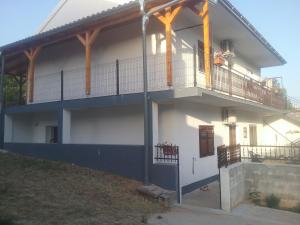 a white house with a balcony with a porch at MILDA+M in Skradin