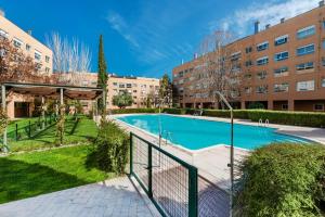 - une piscine dans un complexe d'appartements avec des bâtiments dans l'établissement Los Castaños Design Apartments in Conde Orgaz, à Madrid