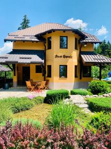 a yellow house with a garden in front of it at Vila Darija Zlatar - studio apartman br 1 in Nova Varoš