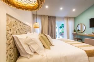 a bedroom with a large white bed and a chandelier at Hotel Mandalas House by DOT Boutique in Santa Marta