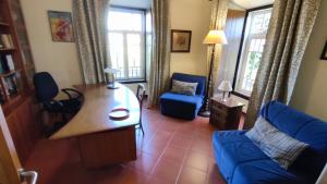 een woonkamer met een blauwe bank en een tafel bij Quinta dos Reis in Alcantarilha