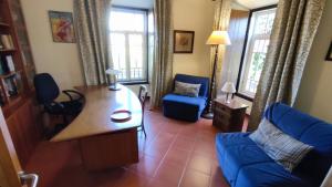 a living room with a blue couch and a table at Quinta dos Reis in Alcantarilha