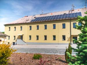 ein gelbes Gebäude mit Sonnenkollektoren auf dem Dach in der Unterkunft Ubytování Na Nové in Bludov