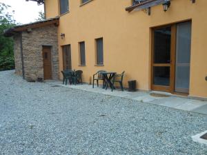 a patio with tables and chairs next to a building at Le Lasarde in Venasca