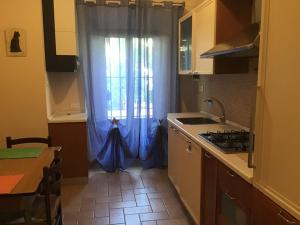 a kitchen with a window with a blue curtain at Albergo Ristorante La Rocca in Firenzuola