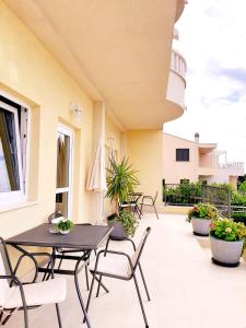 a patio with tables and chairs on a building at Apartments Akmadzic in Makarska