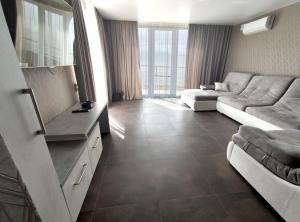 a living room with a couch and a table at Villa Orchidea Sunrise in Zatoka