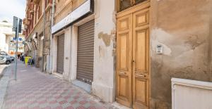 uma porta de madeira na lateral de um edifício em Ichnusa Rooms em Cagliari