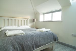 a bedroom with a bed with two towels on it at White Hall Portrush in Portrush