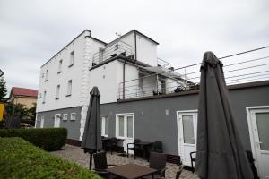a building with tables and umbrellas in front of it at VILLA DIANA USTKA to Twój wypoczynek, wyjątkowy klimat zapraszamy in Ustka