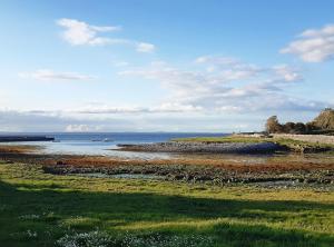 un campo de hierba con el océano en el fondo en Monks Ballyvaughan, en Ballyvaughan