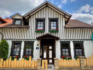 ein weißes Haus mit einem Holzzaun davor in der Unterkunft Ferienwohnung Kniep in Wernigerode