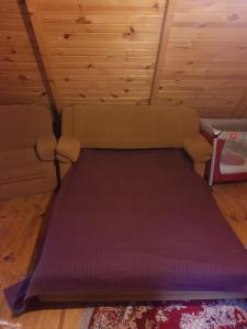 a bed in a room with a purple mattress at Domek w lesie in Aleksandrów