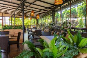 a restaurant with tables and chairs and plants at Hotel Julia in Sveti Vlas