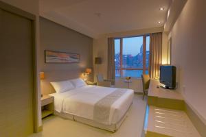 una camera d'albergo con un letto e una televisione di The Salisbury - YMCA of Hong Kong a Hong Kong