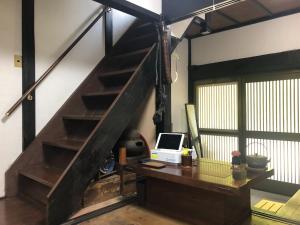 an office with a desk and a staircase with a laptop at Hatago Masara - Vacation STAY 30108v in Tanabe