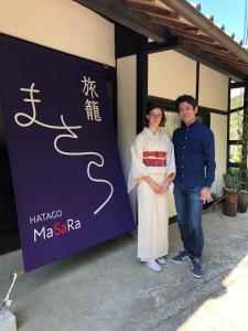 a man and a woman standing in front of a sign at Hatago Masara - Vacation STAY 30108v in Tanabe