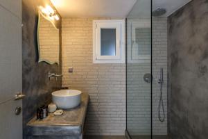 y baño con lavabo y ducha acristalada. en Live & Dream en Vrisi/ Mykonos