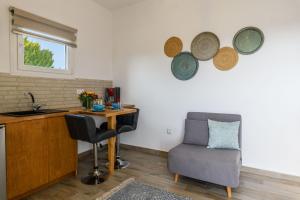 een keuken met een tafel, een stoel en een wastafel bij Live & Dream in Vrisi/ Mykonos