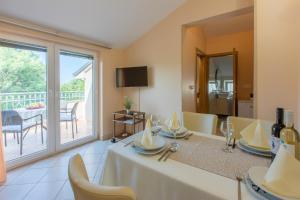 a dining room with a table and a balcony at Amfora Apartments in Crikvenica