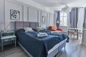 sypialnia z niebieskim łóżkiem i jadalnią w obiekcie Apartamenty Świnoujście - Armii Krajowej 11 w Świnoujściu