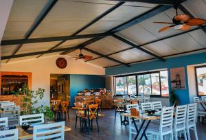 a dining room with tables and white chairs at Zephyros City Otel in Datca