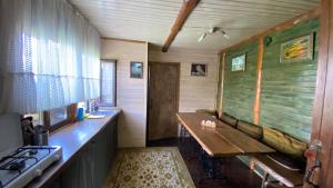 a kitchen with a wooden table and a stove at Flower Street in Svityazʼ