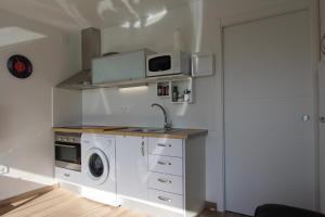 een keuken met een wastafel en een wasmachine bij Lantana Suite-Turis Benidorm in Benidorm