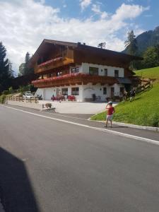 a child standing on the side of a road in front of a building at Hanslerfeld in Alpbach