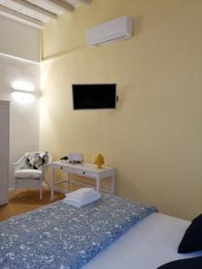 een slaapkamer met een bed en een tv aan de muur bij Corte Barone in Bari
