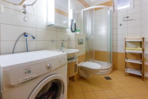 a washing machine in a bathroom with a toilet and a sink at Amfora Apartments in Crikvenica +150 photos