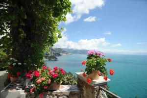 a view of the ocean from a ledge with flowers at Hotel Belvedere in Conca dei Marini