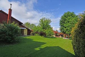 einen grünen Garten mit Bäumen und einem Gebäude in der Unterkunft VIP Apartmany Besenova in Bešeňová
