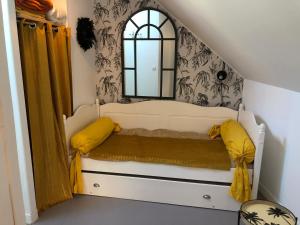a room with a white bed with a mirror at la Discrète in Berck-sur-Mer