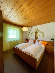 1 dormitorio con 1 cama grande y techo de madera en Apartments Spirit of Mountains en Rasun di Sopra