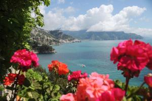 a view of a body of water with pink flowers at Hotel Belvedere in Conca dei Marini