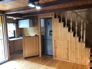 a kitchen with wooden walls and a staircase in a room at Domek letniskowy na Mazurach in Giżycko