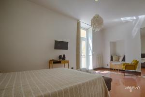 ein weißes Schlafzimmer mit einem Bett und ein Wohnzimmer in der Unterkunft Vesevo Rooms in Neapel