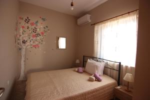 Un dormitorio con una cama con zapatos rosados. en Grammeno Seaside Rooms, en Palaiochóra
