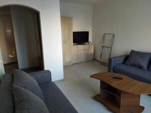 Una sala de estar con un sofá, una mesa y un televisor. en Inzenieru 95 Apartments ., en Ventspils