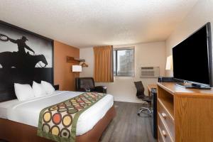 a hotel room with a bed and a flat screen tv at Super 8 by Wyndham Cheyenne WY in Cheyenne