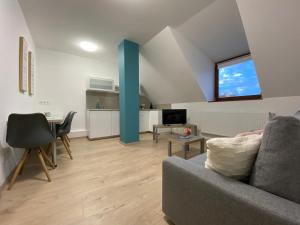 a living room with a couch and a table at Oázis apartmanház in Fertőszentmiklós