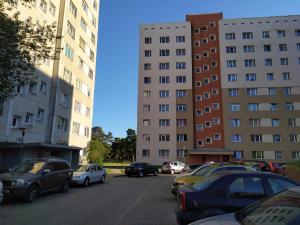 Un grupo de coches estacionados en un estacionamiento al lado de edificios. en Inzenieru 95 Apartments ., en Ventspils
